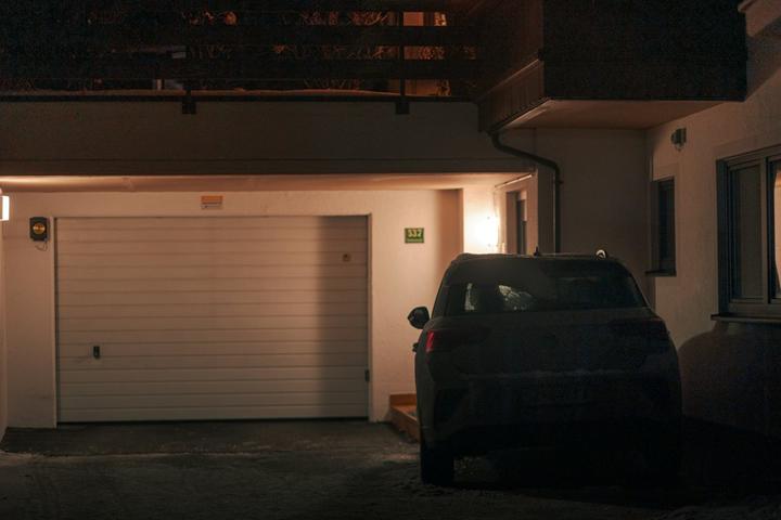Car parked by a garage at night